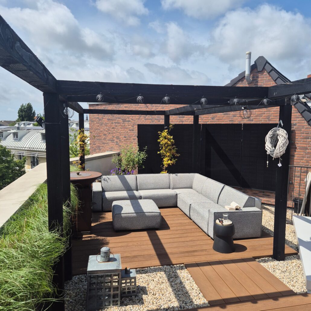 Modern dakterras in Haarlem met zwarte pergola, houten vlonder, eet en loungehoek plus siergrassen