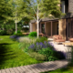 Elegant terras met bloemrijke beplanting en bomen in bosrijke villatuin in Noordwijkerhout